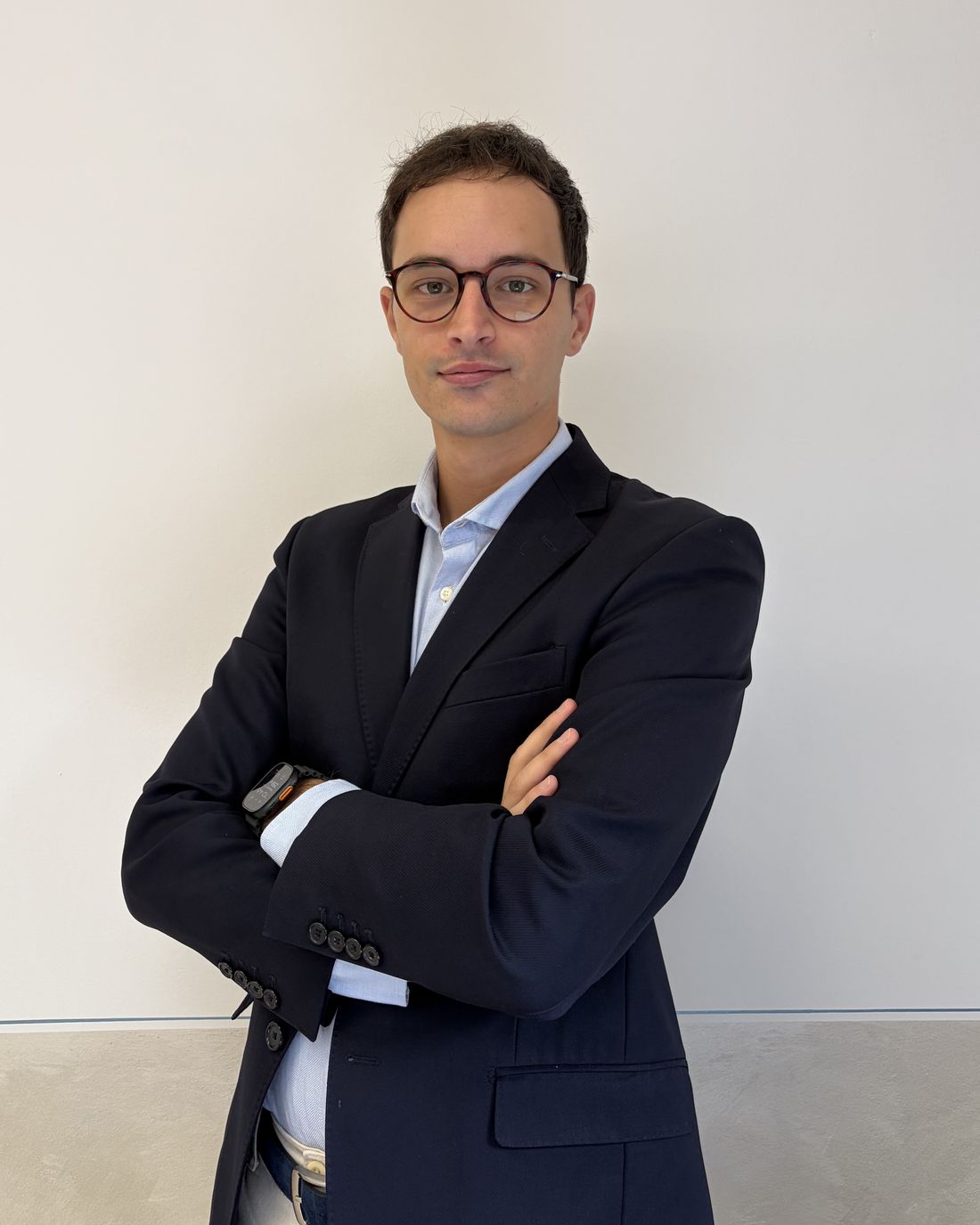 Andrea Torelli con gli occhiali, sorridente, in giacca blu